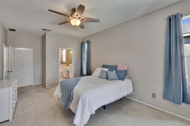 bedroom with baseboards, light carpet, connected bathroom, and visible vents
