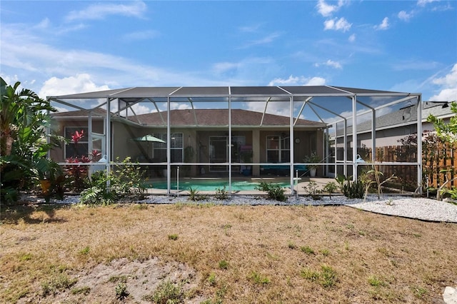 rear view of property featuring a lanai and an outdoor pool