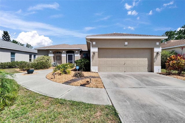 view of front of house featuring concrete driveway, a garage, and stucco siding