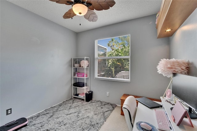 carpeted office space featuring a ceiling fan and a textured ceiling