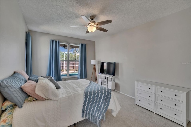 bedroom featuring ceiling fan, light carpet, a textured ceiling, and baseboards