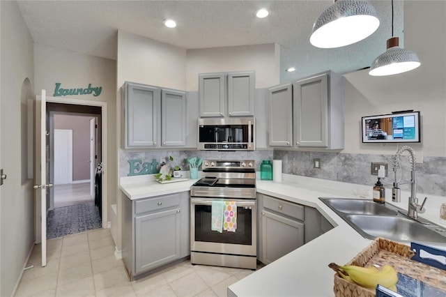 4017 3rd Ave E, Bradenton, FL 34208 - kitchen featuring appliances with stainless steel finishes, gray cabinetry, light countertops, light tile patterned floors, and backsplash