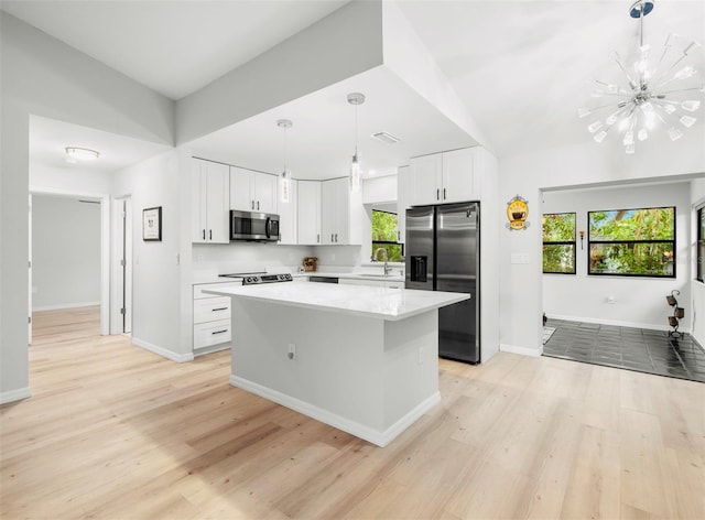 1047 Deer Hollow Way, Sarasota, FL 34232 - kitchen with a center island, a sink, a chandelier, light wood-style floors, and stainless steel appliances