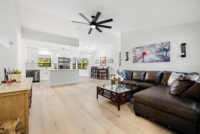 1047 Deer Hollow Way, Sarasota, FL 34232 - living area with ceiling fan with notable chandelier, vaulted ceiling, and light wood-style floors