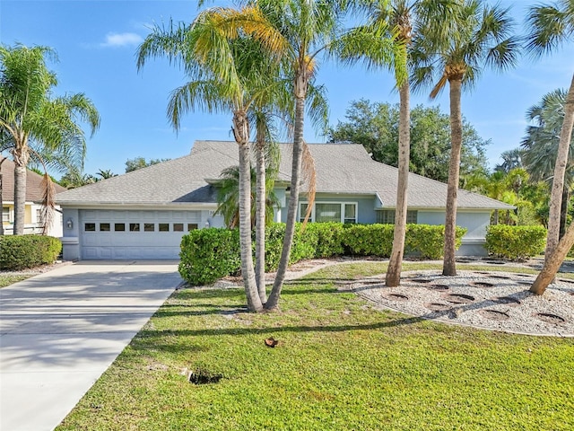 ranch-style home featuring a garage, a front lawn, stucco siding, and concrete driveway