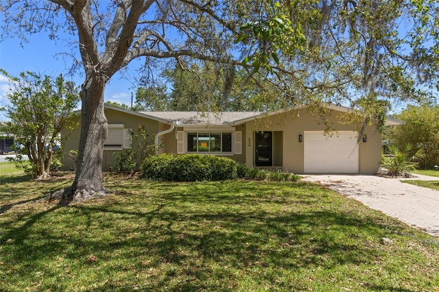 single story home featuring an attached garage, a front lawn, driveway, and stucco siding