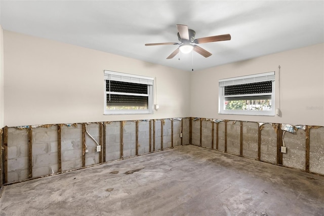 spare room featuring ceiling fan and unfinished concrete floors