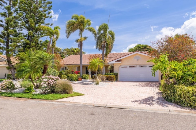 4490 38th Way S, Saint Petersburg, FL 33711 - view of front of home with driveway, a tile roof, a garage, and stucco siding