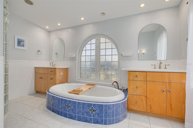 4490 38th Way S, Saint Petersburg, FL 33711 - bathroom featuring a bath, a sink, tile walls, two vanities, and tile patterned flooring