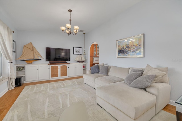 4490 38th Way S, Saint Petersburg, FL 33711 - living area featuring a chandelier, arched walkways, light wood-style flooring, and lofted ceiling