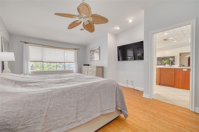 4490 38th Way S, Saint Petersburg, FL 33711 - bedroom with baseboards, ensuite bathroom, lofted ceiling, light wood finished floors, and a sink
