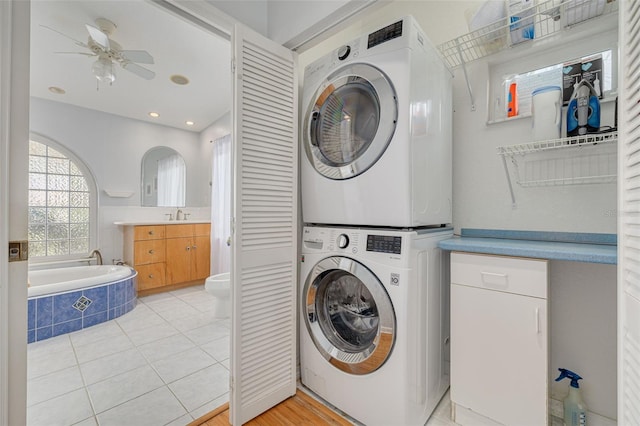 4490 38th Way S, Saint Petersburg, FL 33711 - clothes washing area with light tile patterned floors, a sink, a ceiling fan, laundry area, and stacked washer and dryer