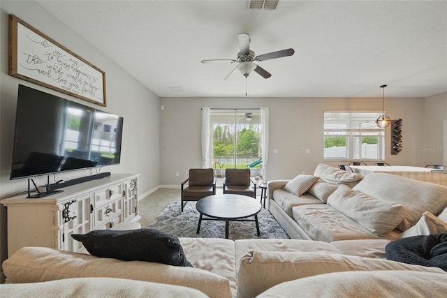living room featuring visible vents, ceiling fan, baseboards, and light tile patterned floors