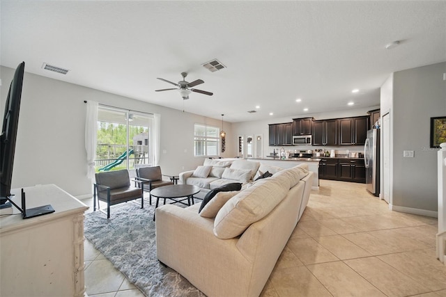 living room with light tile patterned floors, ceiling fan, visible vents, and recessed lighting