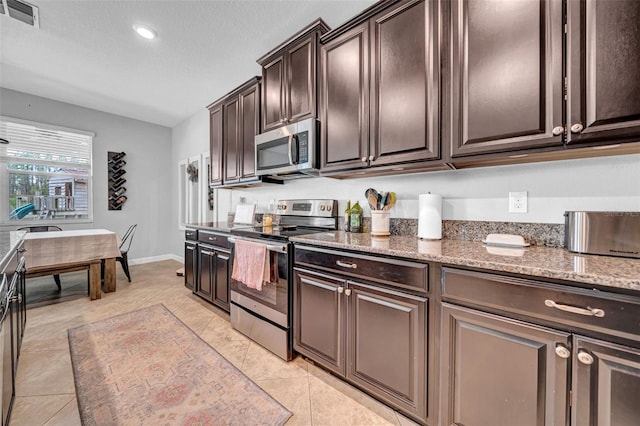 kitchen featuring dark brown cabinets, visible vents, recessed lighting, appliances with stainless steel finishes, and light stone counters