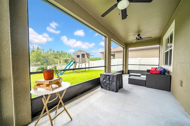 sunroom with a wealth of natural light, outdoor lounge area, and ceiling fan