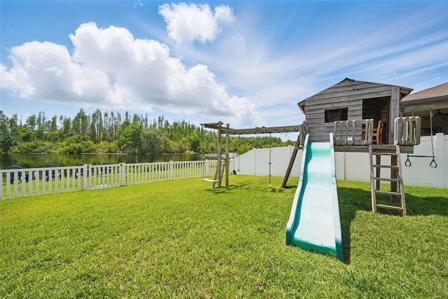 view of play area with a water view, fence, and a lawn