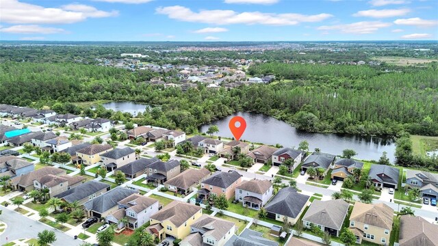 drone / aerial view featuring a water view and a wooded view