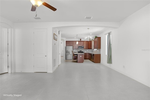 1214 Florablu Dr, Seffner, FL 33584 - kitchen featuring a chandelier, appliances with stainless steel finishes, light countertops, decorative backsplash, and open floor plan