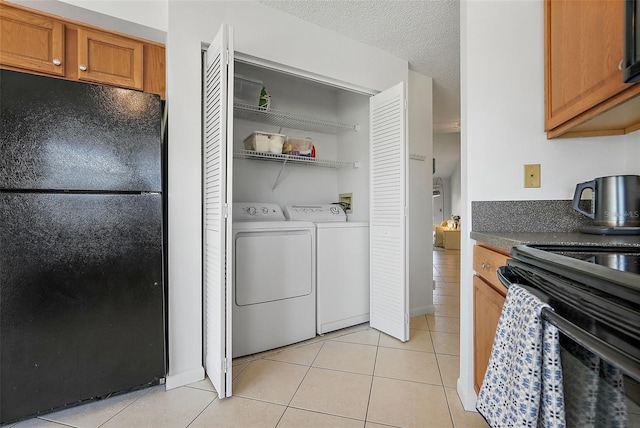6191 Bahia Del Mar Blvd Unit 204, Saint Petersburg, FL 33715 - clothes washing area with light tile patterned floors, separate washer and dryer, laundry area, and a textured ceiling