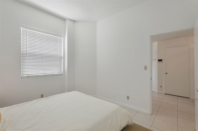 6191 Bahia Del Mar Blvd Unit 204, Saint Petersburg, FL 33715 - bedroom featuring baseboards, light tile patterned flooring, and a textured ceiling