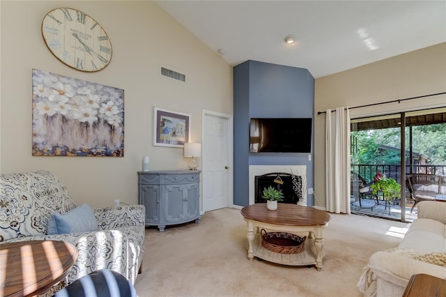 612 Fairmont Ave Unit D, Safety Harbor, FL 34695 - living room with visible vents, high vaulted ceiling, light colored carpet, and a fireplace