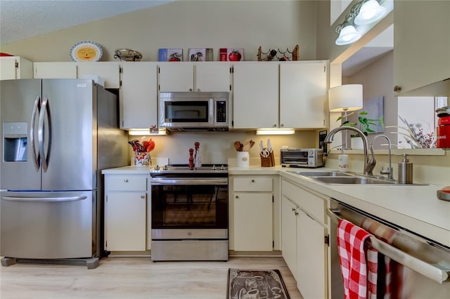 612 Fairmont Ave Unit D, Safety Harbor, FL 34695 - kitchen with appliances with stainless steel finishes, a sink, light countertops, lofted ceiling, and light wood finished floors