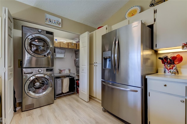 612 Fairmont Ave Unit D, Safety Harbor, FL 34695 - interior space with light wood-type flooring, stacked washer / drying machine, a textured ceiling, and laundry area
