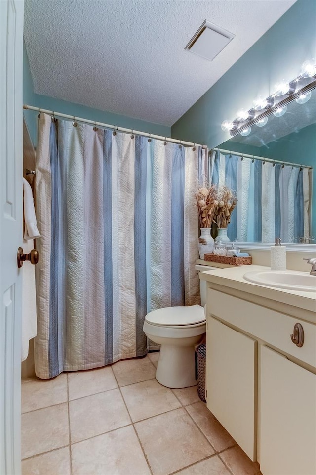 612 Fairmont Ave Unit D, Safety Harbor, FL 34695 - bathroom featuring vanity, tile patterned floors, a textured ceiling, toilet, and visible vents