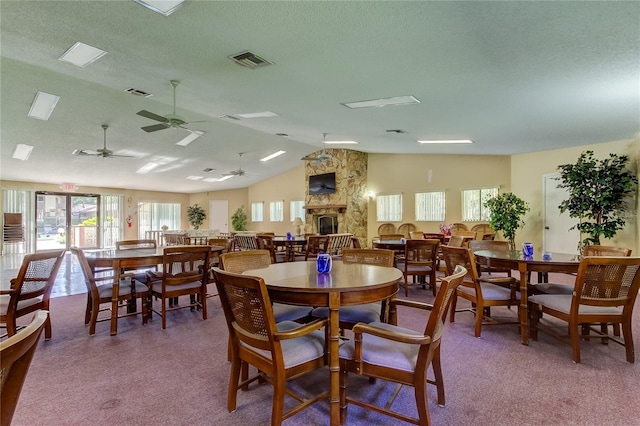 612 Fairmont Ave Unit D, Safety Harbor, FL 34695 - dining area with carpet, a ceiling fan, visible vents, a stone fireplace, and lofted ceiling