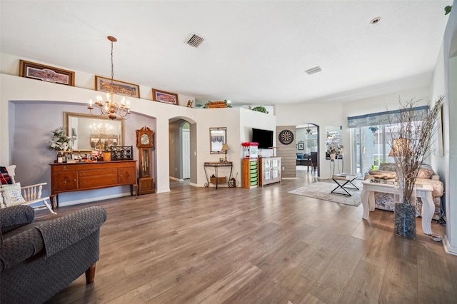 19750 Ellendale Dr, Land O Lakes, FL 34638 - living room with arched walkways, wood finished floors, and a chandelier