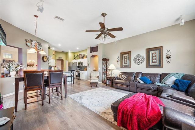19750 Ellendale Dr, Land O Lakes, FL 34638 - living area with arched walkways, ceiling fan, and light wood finished floors