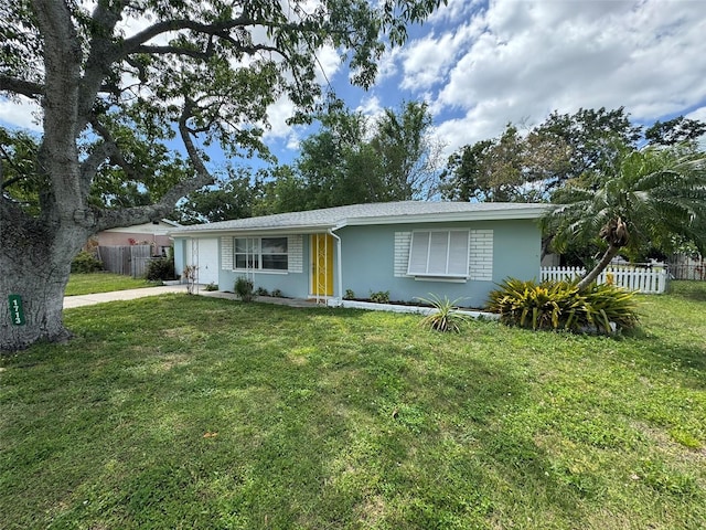 ranch-style home with a front lawn, fence, and driveway