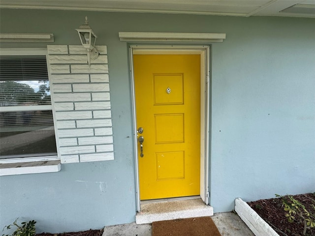 property entrance with stucco siding