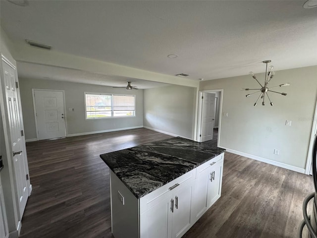 kitchen featuring white cabinets, visible vents, ceiling fan with notable chandelier, and dark wood finished floors