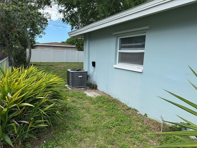 view of yard with central air condition unit and fence