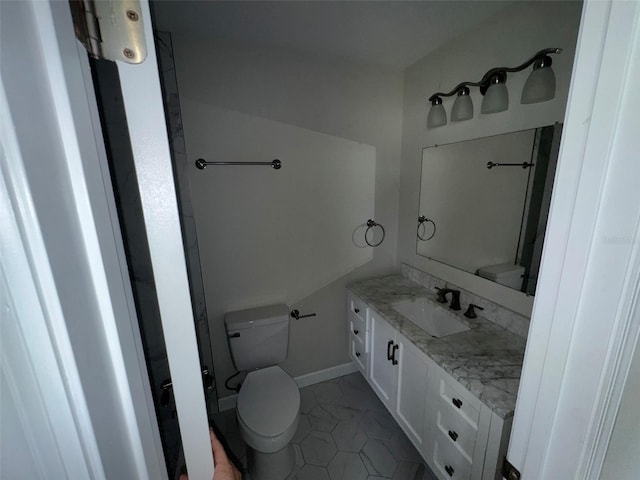 bathroom featuring tile patterned flooring, toilet, vanity, and baseboards