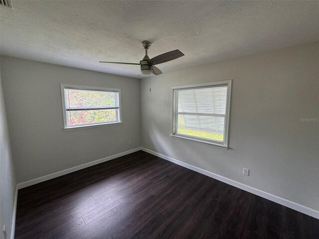 unfurnished room featuring baseboards, a textured ceiling, ceiling fan, and dark wood finished floors