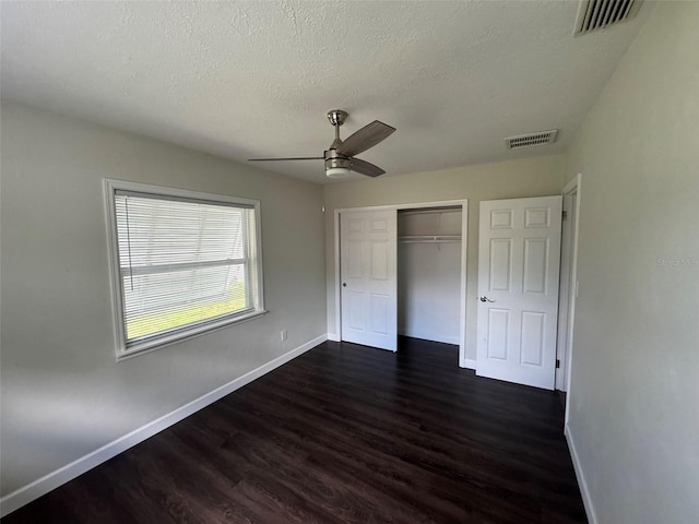 unfurnished bedroom featuring dark wood-type flooring, baseboards, and visible vents