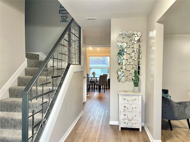 staircase with wood finished floors and baseboards