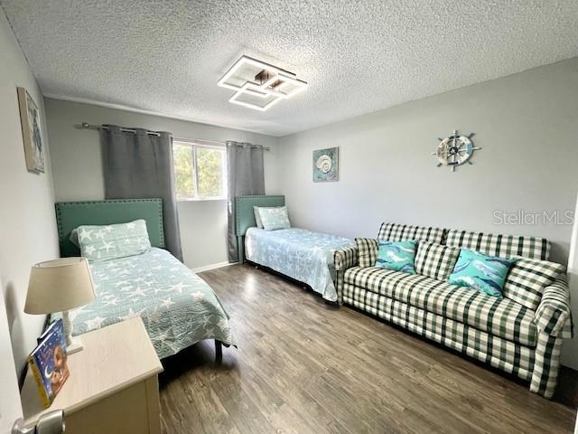 bedroom featuring wood finished floors and a textured ceiling