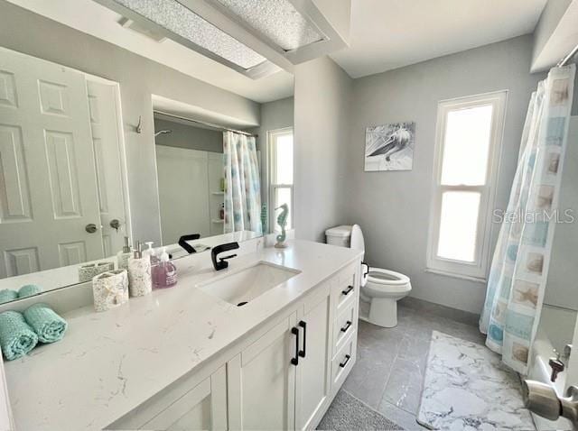 full bath featuring toilet, curtained shower, a wealth of natural light, and vanity