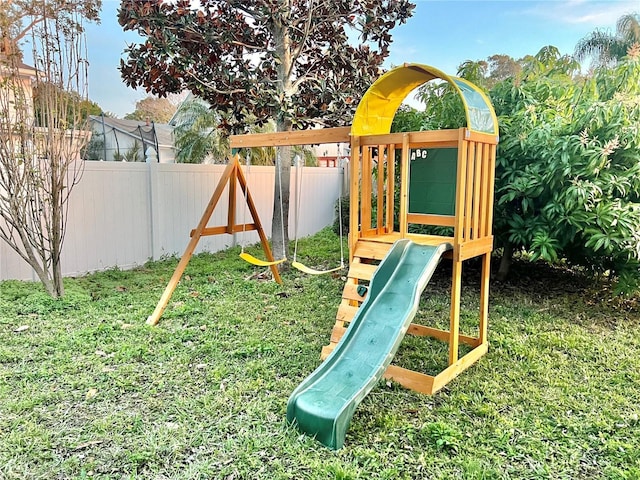 view of jungle gym featuring a lawn and fence private yard