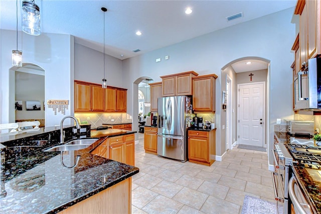 3212 Sunset Lakes Blvd, Land O Lakes, FL 34638 - kitchen featuring stainless steel appliances, a sink, arched walkways, decorative backsplash, and recessed lighting