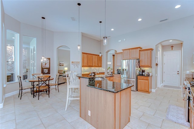 3212 Sunset Lakes Blvd, Land O Lakes, FL 34638 - kitchen featuring arched walkways, stainless steel refrigerator with ice dispenser, a sink, dark stone countertops, and recessed lighting