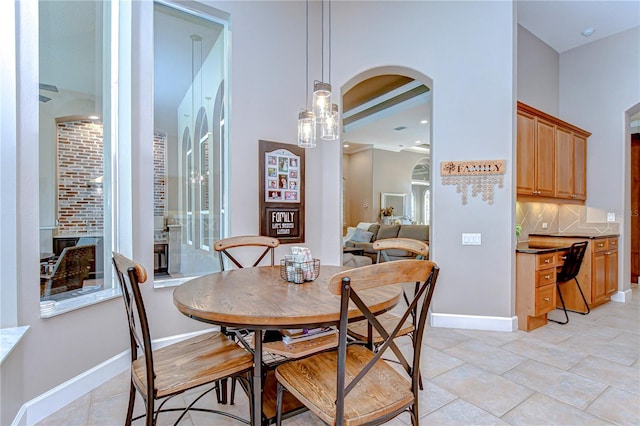 3212 Sunset Lakes Blvd, Land O Lakes, FL 34638 - dining room featuring arched walkways, light tile patterned floors, and baseboards