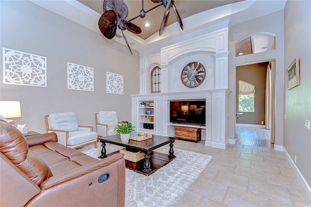 3212 Sunset Lakes Blvd, Land O Lakes, FL 34638 - living area featuring baseboards, a ceiling fan, a fireplace, and a tray ceiling