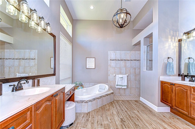 3212 Sunset Lakes Blvd, Land O Lakes, FL 34638 - full bath with walk in shower, a chandelier, a bath, two vanities, and wood finished floors