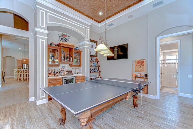 3212 Sunset Lakes Blvd, Land O Lakes, FL 34638 - rec room featuring ornate columns, arched walkways, ornamental molding, a dry bar, and light wood-type flooring