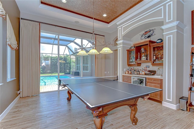 3212 Sunset Lakes Blvd, Land O Lakes, FL 34638 - playroom with ornate columns, bar, ornamental molding, a tray ceiling, and light wood-style flooring
